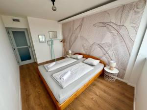 a bedroom with a bed with a painting on the wall at Panorama View Deluxe Apartment in Veszprém