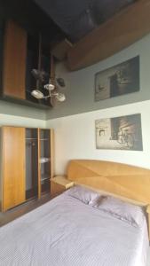 ein Schlafzimmer mit einem Bett mit einem hölzernen Kopfteil in der Unterkunft Apartament Faleza Tiglina in Galaţi