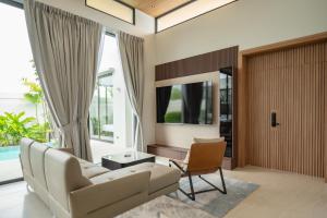 un soggiorno con divano bianco e sedia di Mouana Residence Song Khun Chalong VIP4-bedroom Pool Villa 89-14 a Chalong