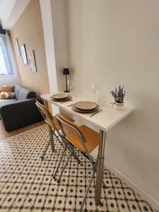 a dining table with two chairs in a living room at Forest Studio - Ground Floor - City Center - Train station 5 minutes away in Charleville-Mézières