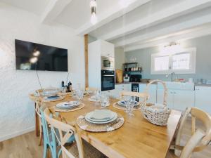 een eetkamer met een houten tafel en stoelen bij Maison 3 chambres - Central - Proche du lac in Esparron-de-Verdon