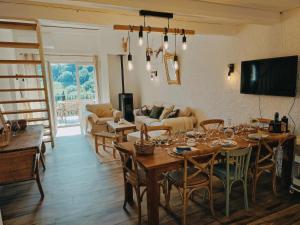 een woonkamer met tafels en stoelen en een bank bij Maison 3 chambres - Central - Proche du lac in Esparron-de-Verdon