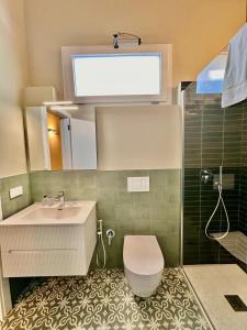 a bathroom with a sink and a toilet and a shower at Dimora Aquae Suites&Spa in Mola di Bari