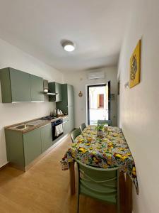 a kitchen with a table with chairs and a kitchen with a tableablish at Domus Apartament in Capo dʼOrlando