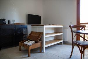 a living room with a tv and a table and a chair at Le Stanze del Convento San Giuseppe in Cagliari