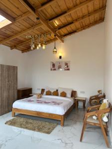 Un dormitorio con una cama grande y un techo de madera. en The Frozen Valley 4BHK Villa, en Mukteshwar