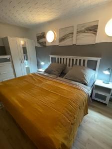a bedroom with a large bed with a yellow blanket at Ferienwohnung Sonnenschein in Dranske