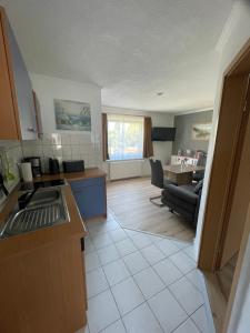a kitchen with a sink and a living room at Ferienwohnung Sonnenschein in Dranske