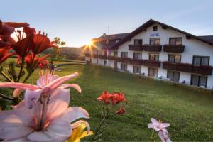 ein Hotel auf einem Hügel mit Blumen im Vordergrund in der Unterkunft Urlaubshotel Binder in Büchlberg