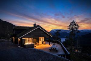 a house on a hill with a sunset in the background at Skyline Lodge in Stryn