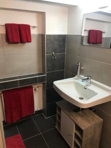 ein Badezimmer mit einem weißen Waschbecken und roten Handtüchern in der Unterkunft Ferienwohnung Winterberg in Winterberg