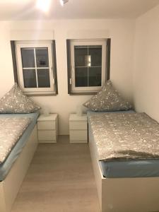 zwei Betten in einem Zimmer mit zwei Fenstern in der Unterkunft Ferienwohnung Winterberg in Winterberg