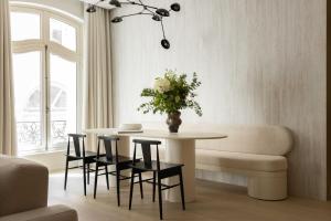 a living room with a table and chairs and a couch at Rive 15 - Appartements Parisiens in Paris