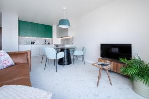 a living room with a couch and a table at Widzewska Chic Apartment by BookingHost in Łódź