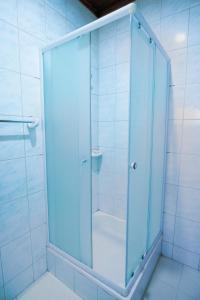 a shower with a glass door in a bathroom at Kacyiru House Golf Course Views in Kigali