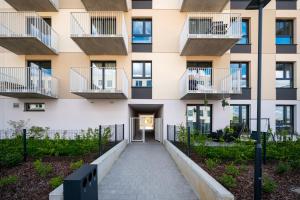 an apartment building with balconies and a walkway at Widzewska Chic Apartment by BookingHost in Łódź