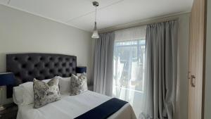 a bedroom with a bed and a large window at Greenlee Lifestyle Apartment- 2 Bedroom in Sandton