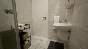 a small bathroom with a sink and a shower at Greenlee Lifestyle Apartment- 2 Bedroom in Sandton +19 photos