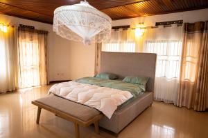 a large bed in a room with a chandelier at Kacyiru House Golf Course Views in Kigali