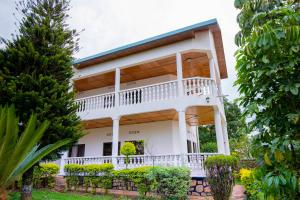 a large white house with a large balcony at Kacyiru House Golf Course Views in Kigali