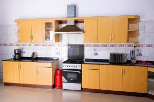 a kitchen with wooden cabinets and a stove at Kacyiru House Golf Course Views in Kigali +34 photos