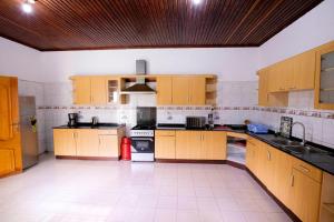 a large kitchen with wooden cabinets and appliances at Kacyiru House Golf Course Views in Kigali
