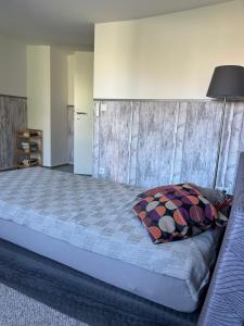 ein Schlafzimmer mit einem großen Bett und einer Holzwand in der Unterkunft Brücke26 Stadthaus mit Dachterrasse in Mühlhausen