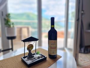 多布罗塔Victor Kotor Sea view的桌子上坐着一瓶葡萄酒