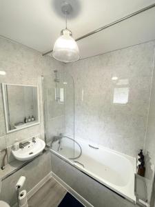 ロンドンにあるPerfect Stay Close to Centre Londonの洗面台と浴槽と洗面台のあるバスルーム