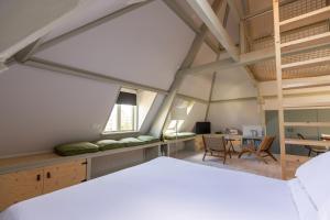 Un dormitorio abuhardillado con una cama y un escritorio. en Huis Delfshaven, en Middelburg