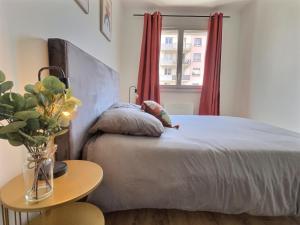 a bedroom with a bed with a doll laying on it at L'artiste - centre ville in Valence
