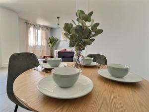 a wooden table with cups and plates on top of it at L'artiste - centre ville in Valence
