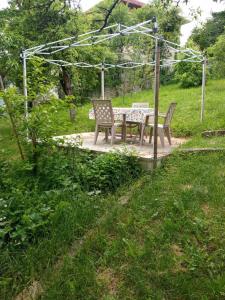 a picnic table and two chairs in a garden at Roam&Rest Sarajevo in Sarajevo