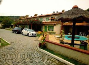 Casa Aquamarina Buzios في بوزيوس: منزل مع سيارتين متوقفتين أمامه