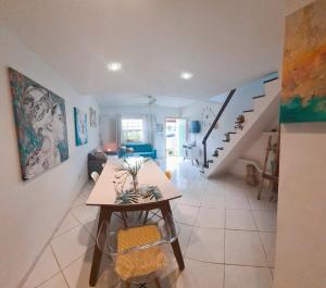 Casa Aquamarina Buzios في بوزيوس: غرفة معيشة مع طاولة ودرج