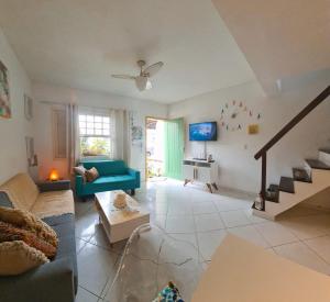 Casa Aquamarina Buzios في بوزيوس: غرفة معيشة مع أريكة زرقاء ودرج