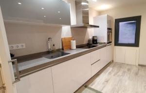 a kitchen with white cabinets and a sink and a window at Bella Lucía in Lloret de Mar
