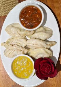 a plate of food with dumplings and dipping sauce at Hotel Bagla Atithi Banaras in Varanasi