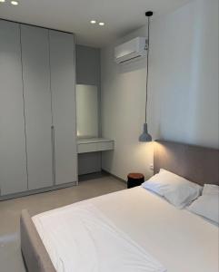a bedroom with a white bed and a white cabinet at Even Residence Green Coast Palase in Palasë +16 photos