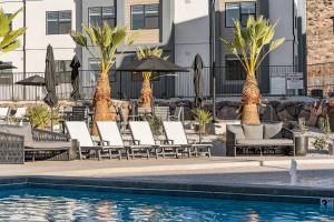 Una piscina con sillas y sombrillas al lado de un edificio. en Poolside at Terra condo, en Hurricane