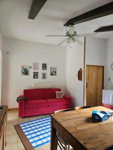 a living room with a red couch and a table at La casa di Marta in Campo Tizzoro