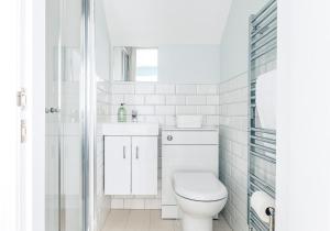 a white bathroom with a toilet and a sink at Little Copse, Elie in Elie +28 photos