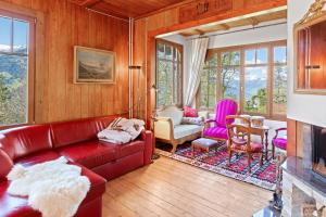 un soggiorno con divano e sedie in pelle rossa di Grand chalet rustique à Gryon, avec vue et cheminée a Gryon