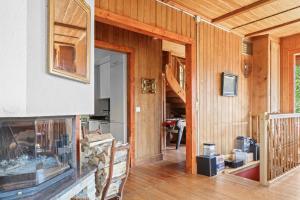 un soggiorno con pareti rivestite in legno e una porta di Grand chalet rustique à Gryon, avec vue et cheminée a Gryon