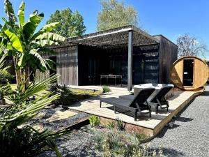 a building with a table and chairs in a garden at Éco-Lodge avec son Spa Privatif in Mios