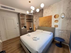 a bedroom with a large white bed and a blue stool at Maison Rasella Palace Suites in Rome