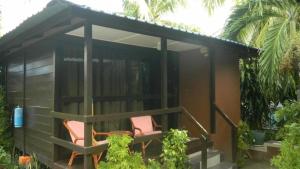 邦咯Nipah Bay Villa的一个小房子的门廊上两把椅子