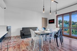 a dining room with a table and chairs and a couch at Villa Carli by Aurora - Superior Apartment in Soiano del Lago