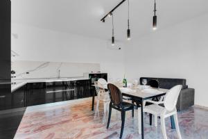 a dining room with a table and chairs and a kitchen at Villa Carli by Aurora - Superior Apartment in Soiano del Lago +20 photos