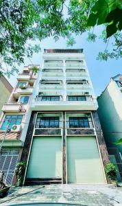 Văn TrìCăn hộ tiện nghi tại 214 Phú Diễn的一座有两扇大窗户的高大白色建筑